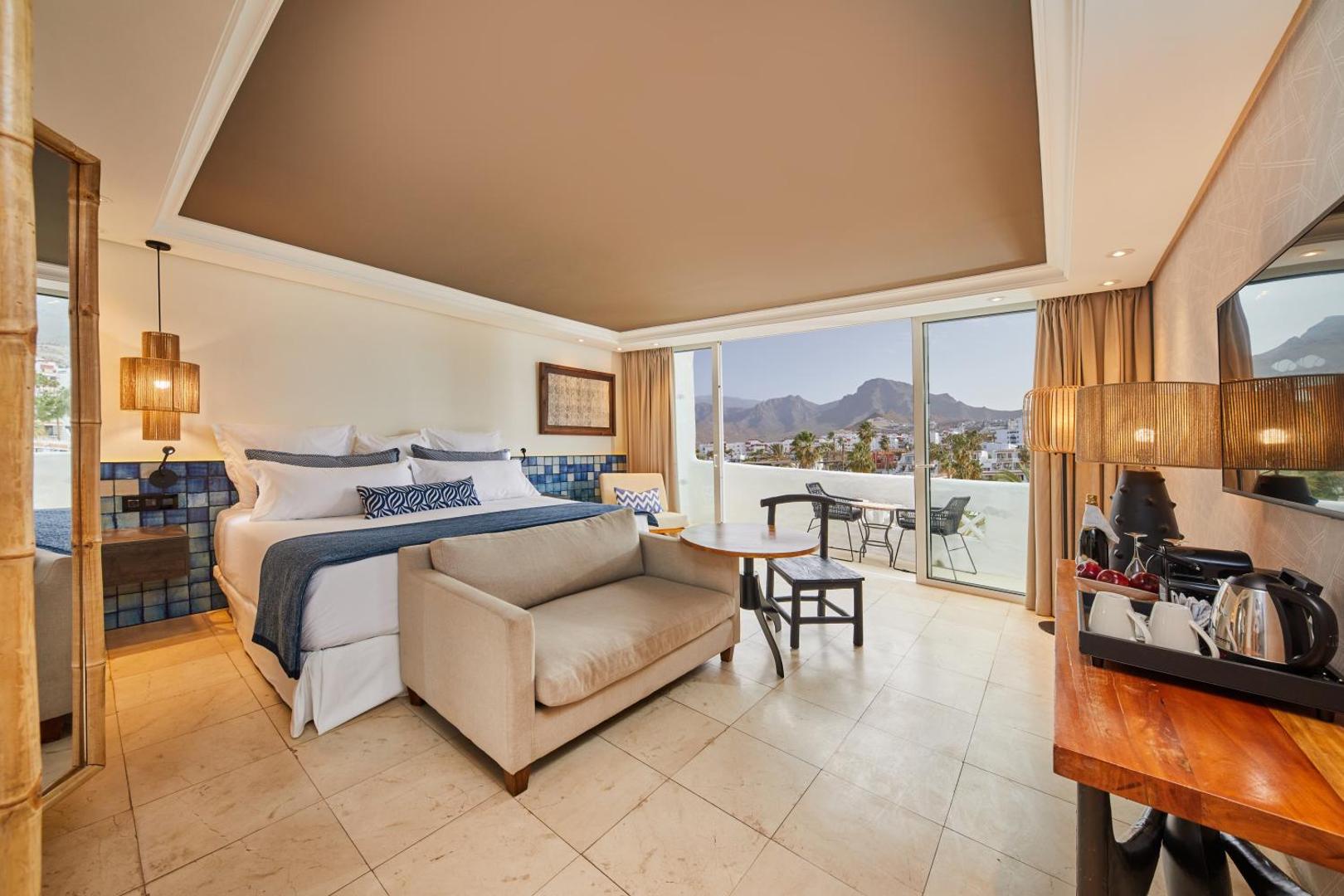 Dreams Jardin Tropical Resort & Spa plašs viesnīcas numurs ar atpūtas zonu, terasi un panorāmas skatu uz pilsētu un kalniem