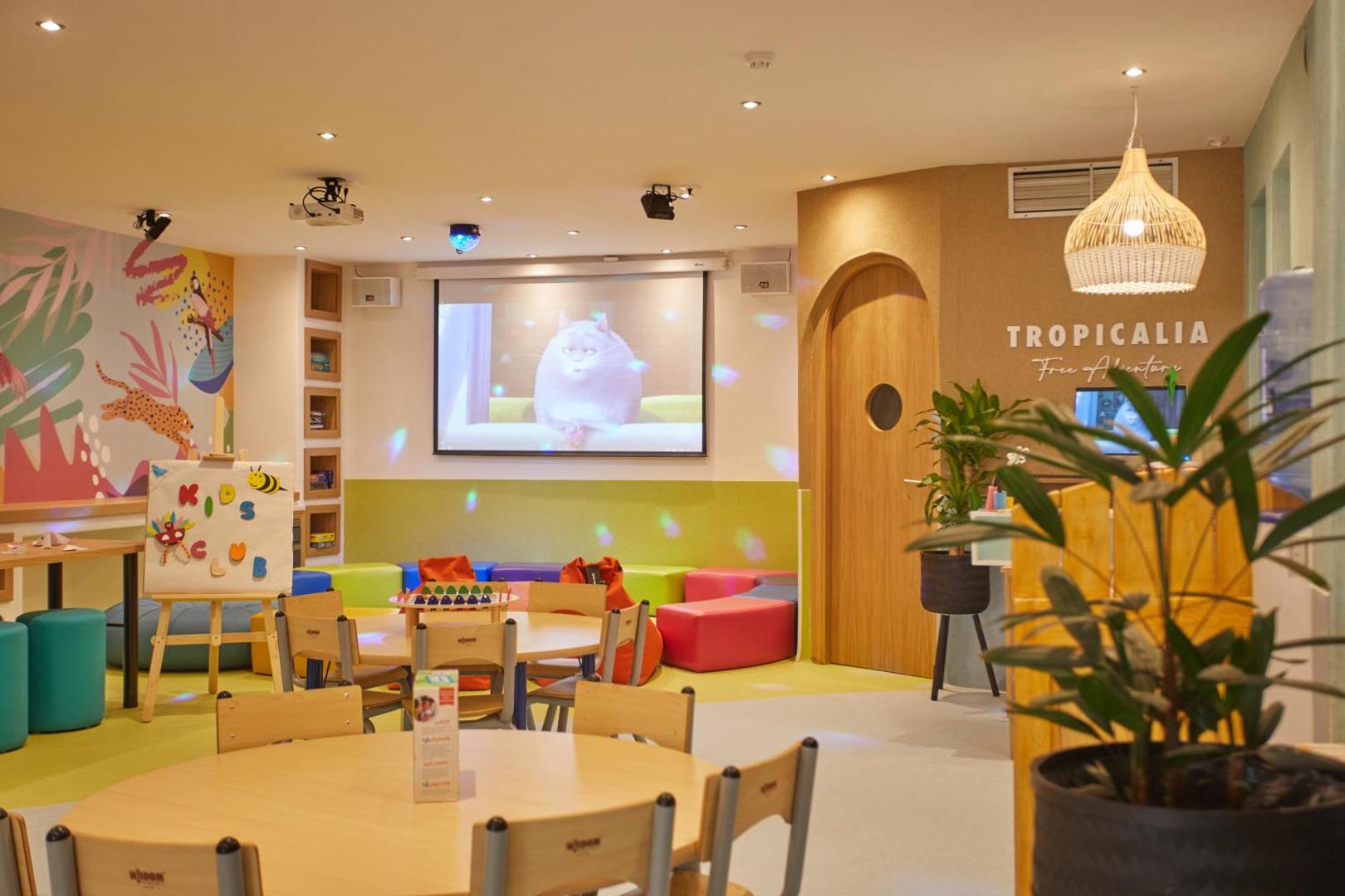 Viesnīcas Dreams Jardin Tropical Resort & Spa bērnu klubs Tropicalia ar spēļu galdiem, mīkstajiem sēžammaisiem un lielu ekrānu multfilmām