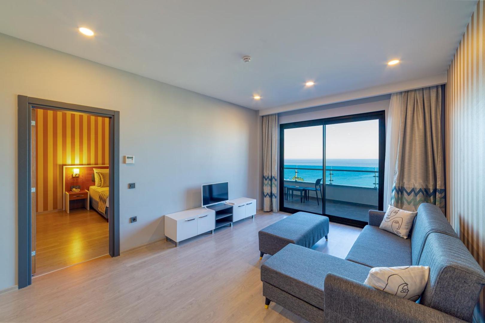 Lonicera Premium plašs viesnīcas numurs ar atsevišķu dzīvojamo zonu, dīvānu un lielu panorāmas logu uz jūras pusi.