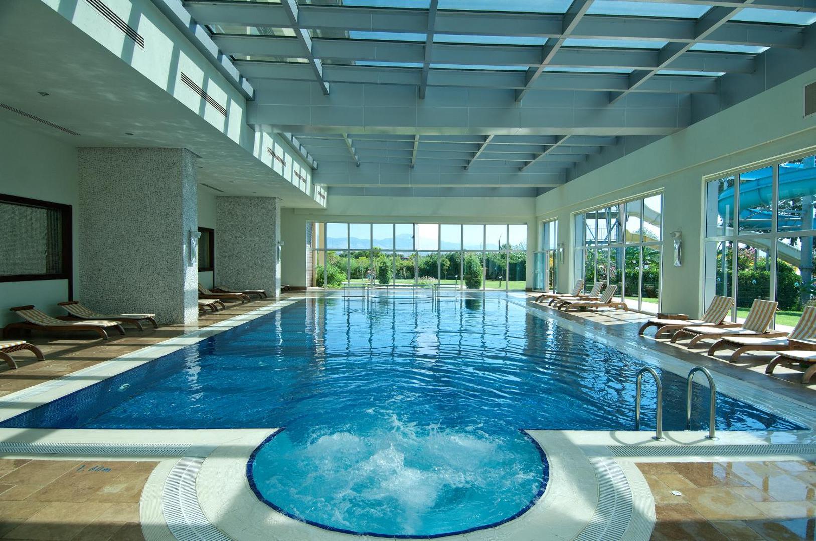 Marvida Family Eco iekštelpu baseins ar džakuzi zonu un panorāmas logiem uz dārzu viesnīcas spa centrā