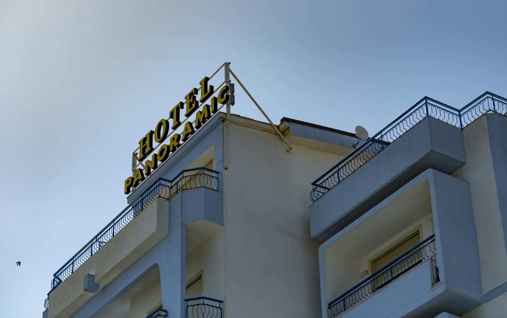 Tuvplāns Hotel Panoramic izgaismotajai izkārtnei uz viesnīcas jumta pret skaidrām debesīm Sicīlijā
