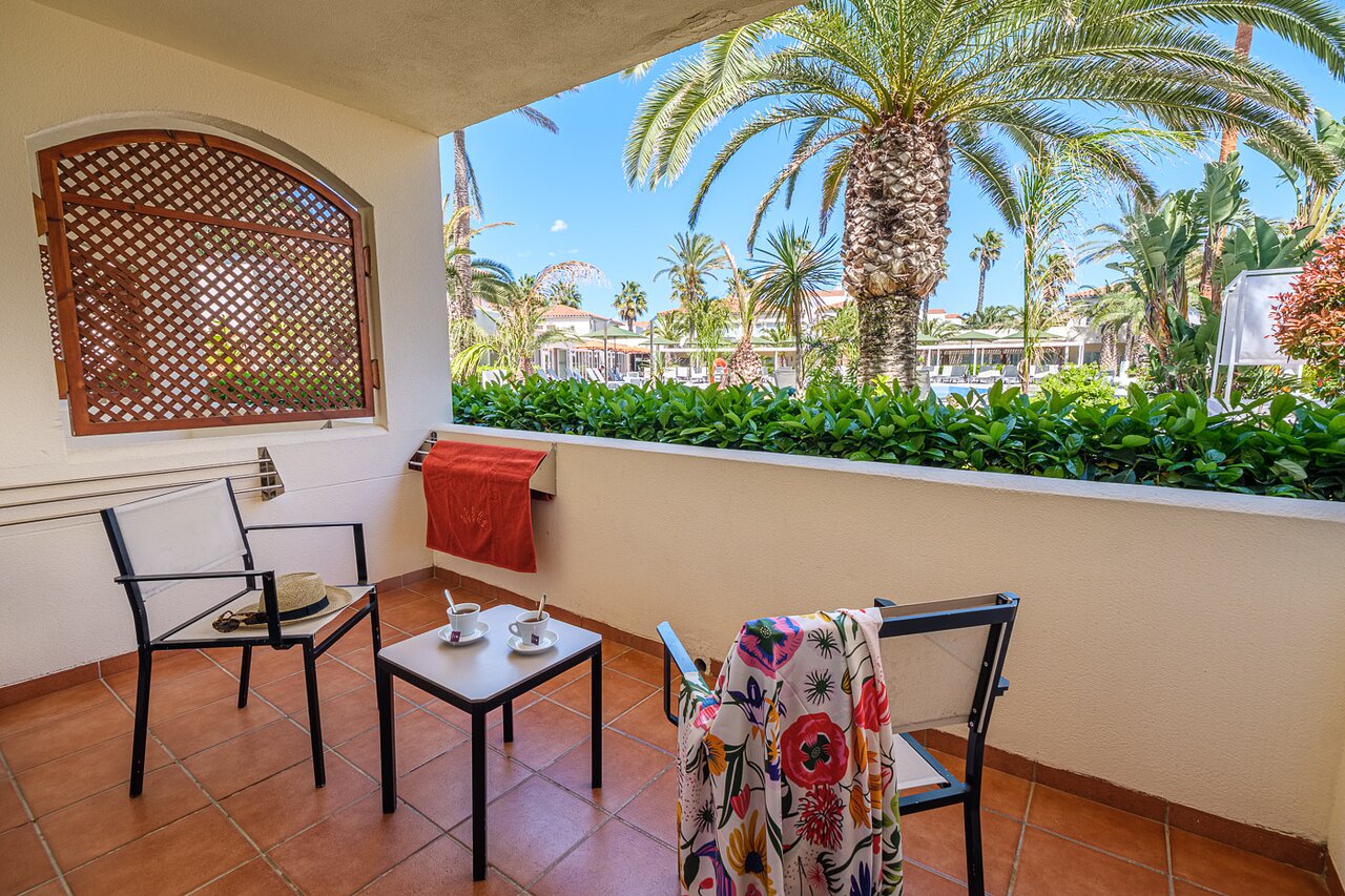 Oassium Hotel - Adults Only privātā terase ar skatu uz dārzu un palmām relaksējošai atpūtai.