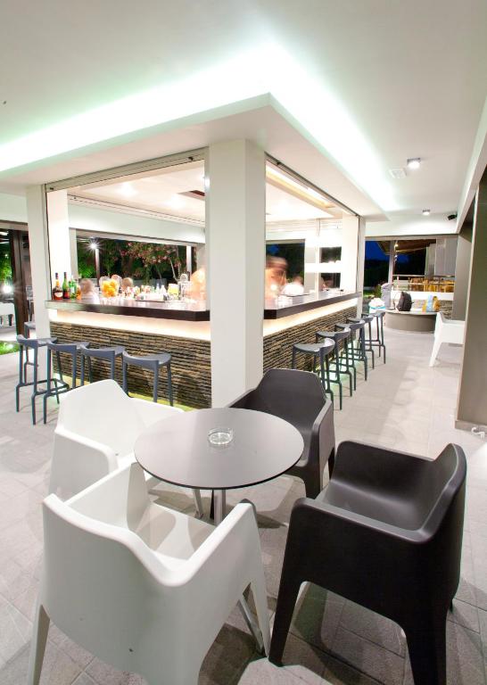 Moderna bāra zona pie Matoula Beach Hotel ar elegantiem krēsliem un apgaismojumu.
