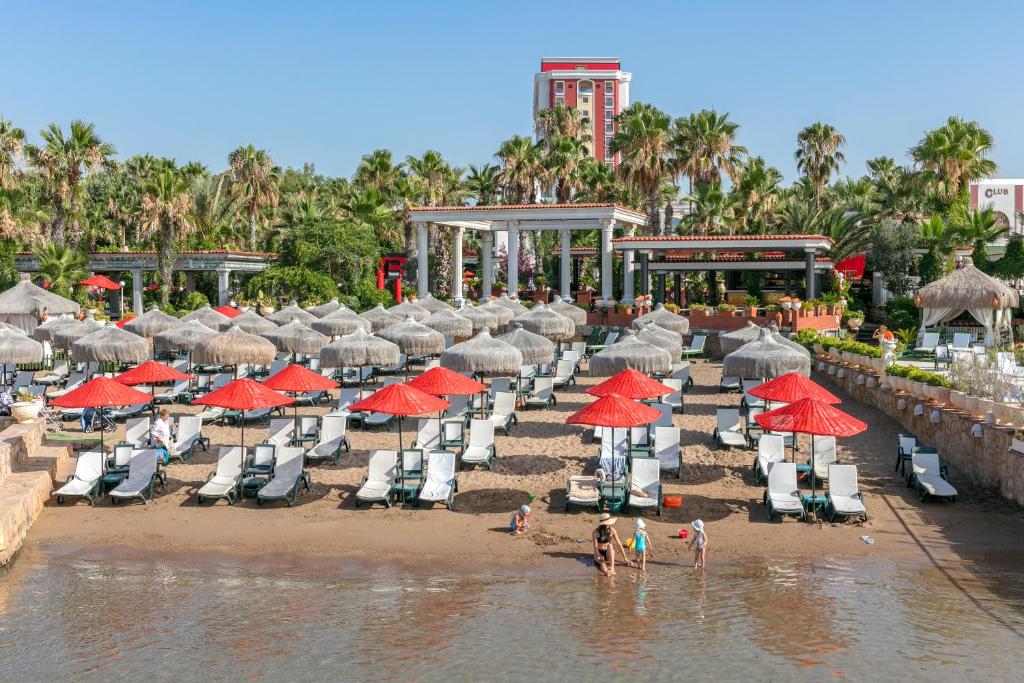 Pludmale ar saulessargiem un guļamkrēsliem pie Club Hotel Sera