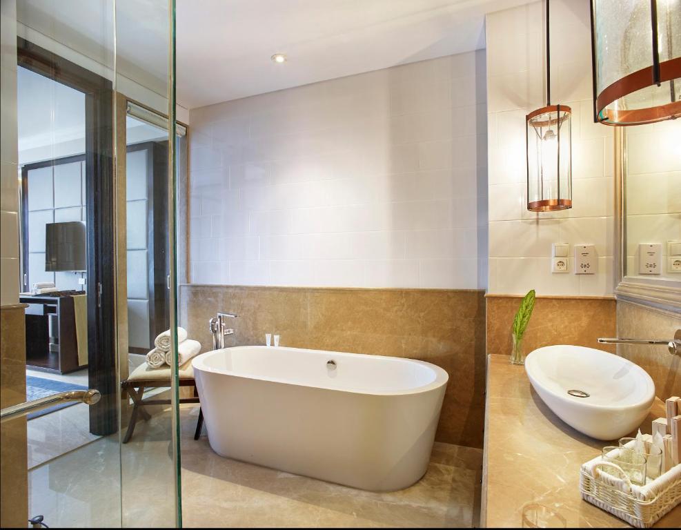 Mūsdienīgs vannas numurs ar atvērtu dušu un brīvi stāvošu vannu Jambuluwuk Oceano Seminyak.