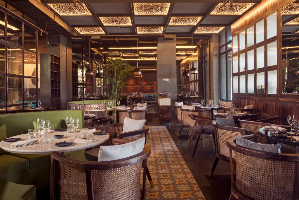 Restorāns Jambuluwuk Oceano Seminyak ar elegantiem galdiem un modernu interjeru.