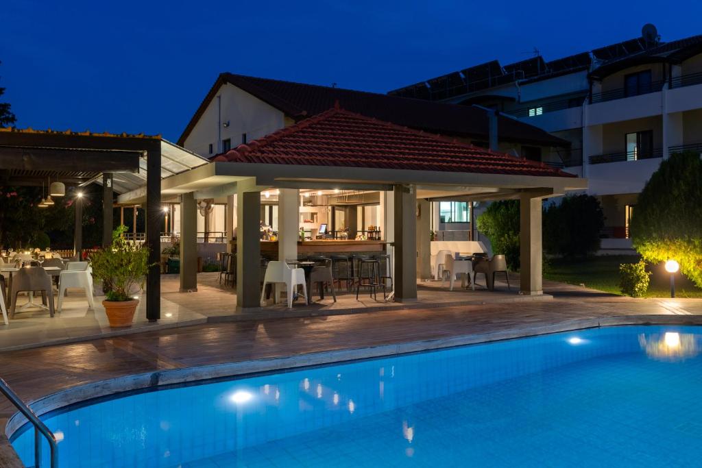 Matoula Beach Hotel terase pie baseina naktī ar apgaismojumu