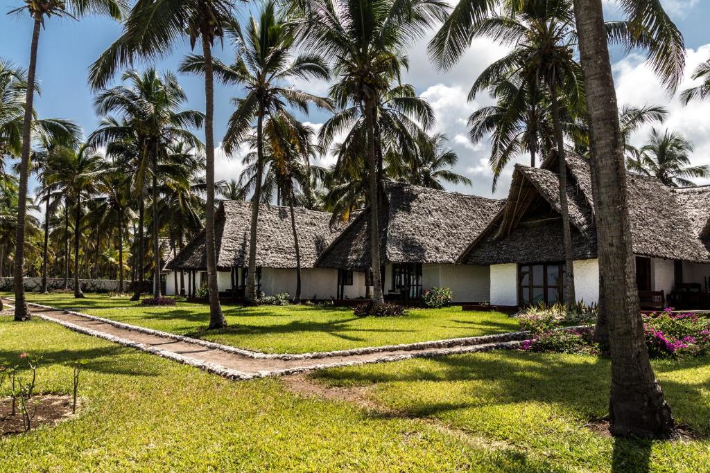 Karafuu Beach Resort & Spa tradicionālās villas un palmas