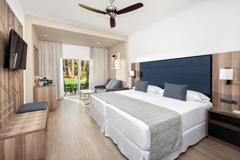 Mūsdienīgs viesnīcas numurs ar divguļamo gultu, ērtu dīvānu un balkonam ar skatu uz dārzu. Numurā ir televizors, kafijas automāts un eleganta koka mēbeles.