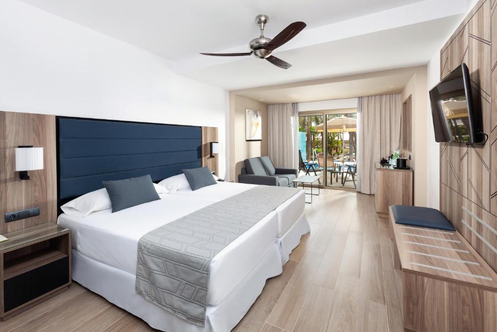 Moderns viesnīcas numurs ar divām gultām, stilīgu interjeru un balkonu, kas izgaismots ar dabīgu gaismu. Numurā ir televizors, ērtas mēbeles un skats uz dārzu.