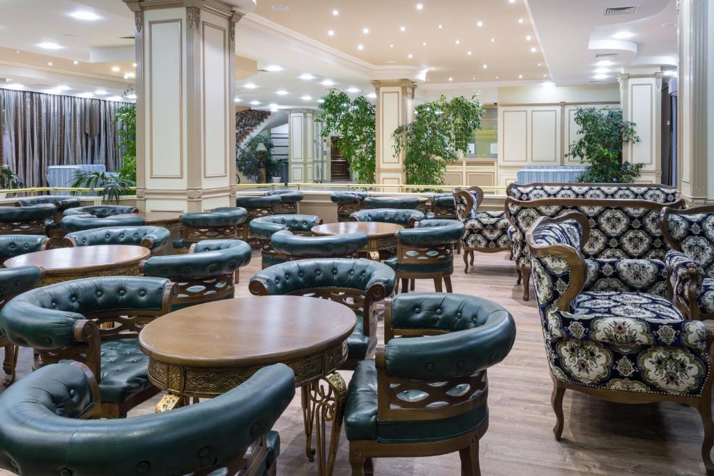 Elegants kafijas veikals ar greznām mēbelēm, kuras rotā zaļas augu kompozīcijas. Šis interjers piedāvā komfortablu un patīkamu atmosfēru.