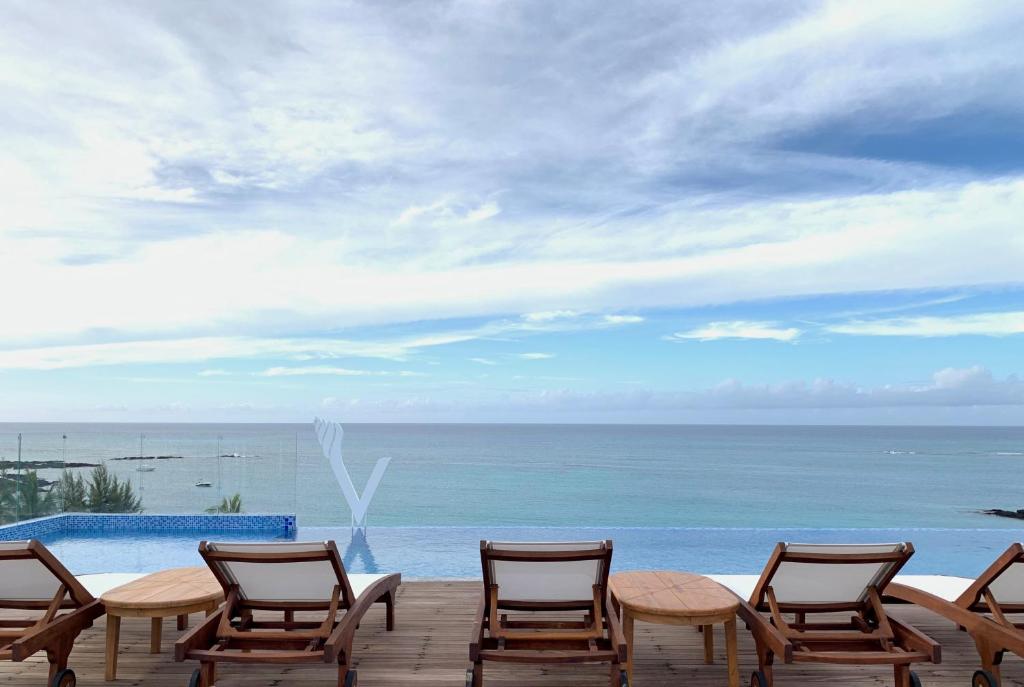 Skats uz jūru no Ocean V viesnīcas baseina zonas ar sauļošanās krēsliem.