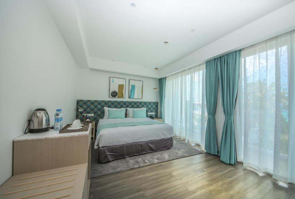 Mūsdienīgs numurs viesnīcā Ocean V ar lieliem logiem un ērtu gultu.