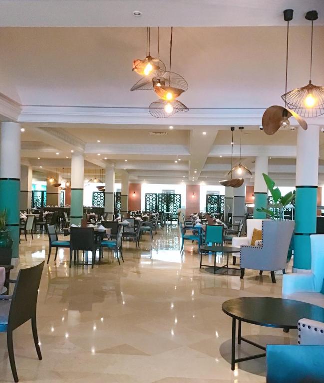 Mūsdienīgs restorāns ar elegantiem galdiem un krēslām, apgaismots ar stilīgām lampām. Telpā ir plaša un gaiša atmosfēra, kas aicina apmeklētājus baudīt maltītes.