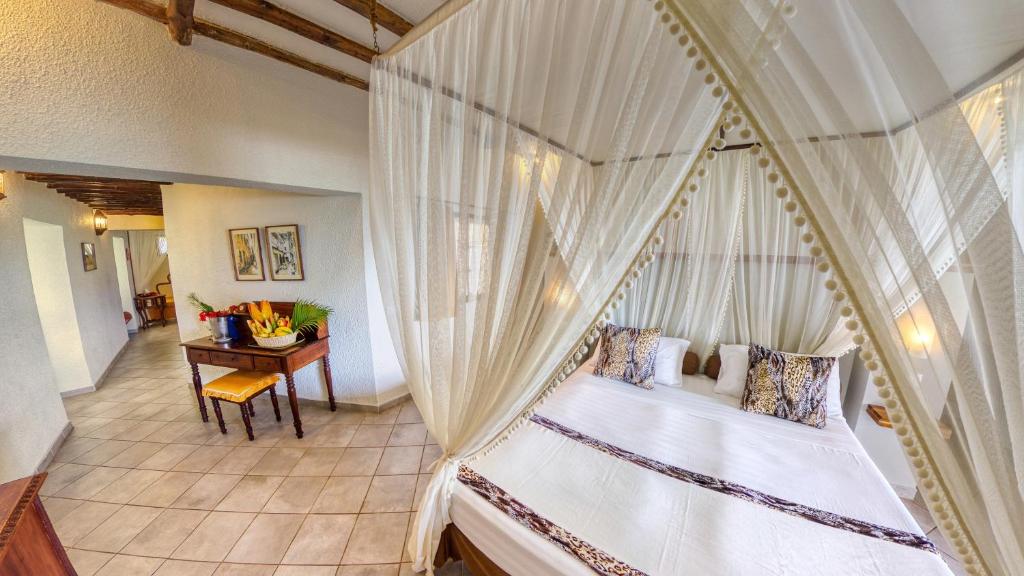 Karafuu Beach Resort & Spa numurs ar baldahīna gultu un dekorācijām