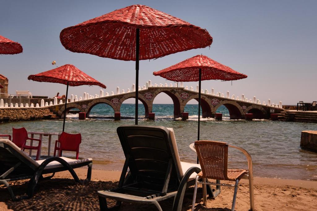 Pludmales skats ar sarkaniem saules sargiem un tiltu pie Club Hotel Sera