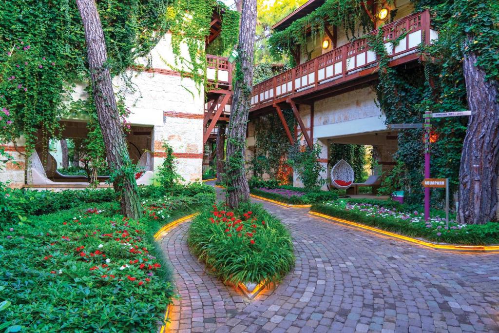 Ulusoy Kemer Holiday Club dārza ceļš ar ziediem un apzaļumotu vidi