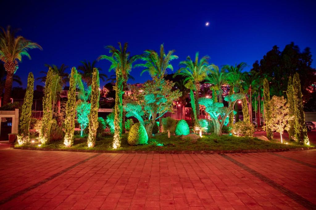 Viegli apgaismotā dārza ainava pie Hotel Baia Bodrum naktī.