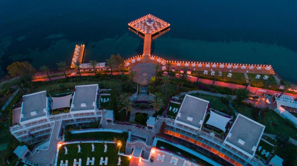 Skats no augšas uz Hotel Baia Bodrum piekrasti ar apgaismotu promenādi.