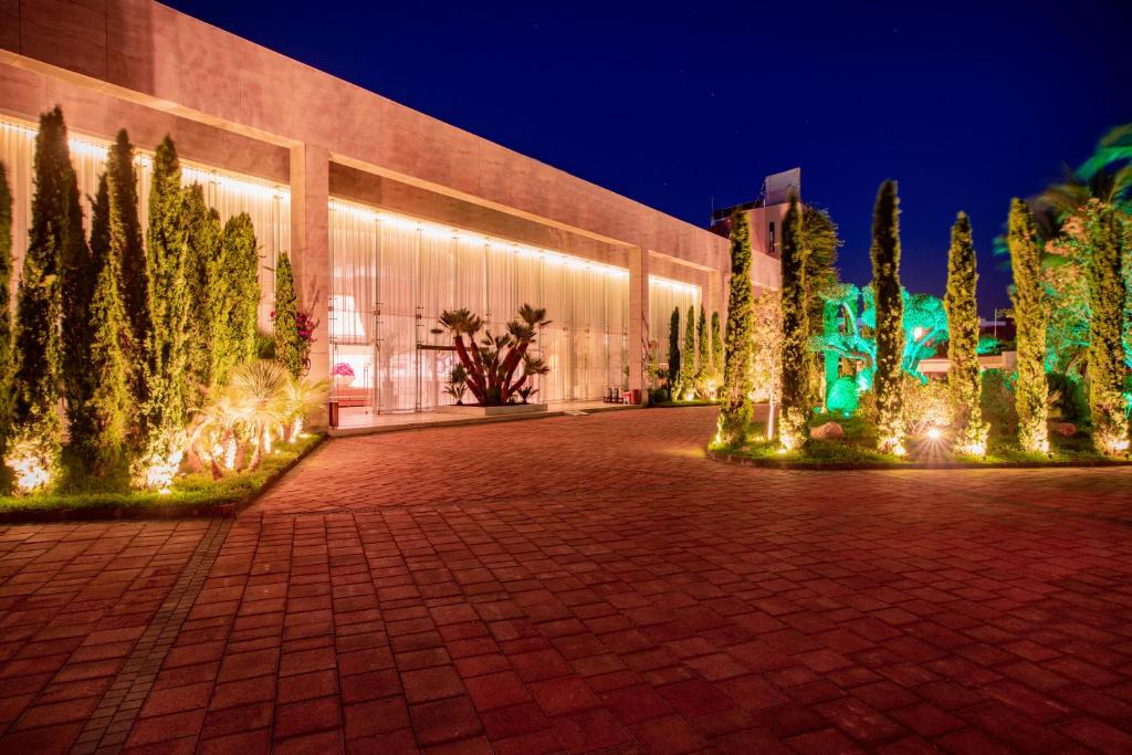 Viesnīcas Baia Bodrum ieeja naktī ar apgaismotām augu kompozīcijām.