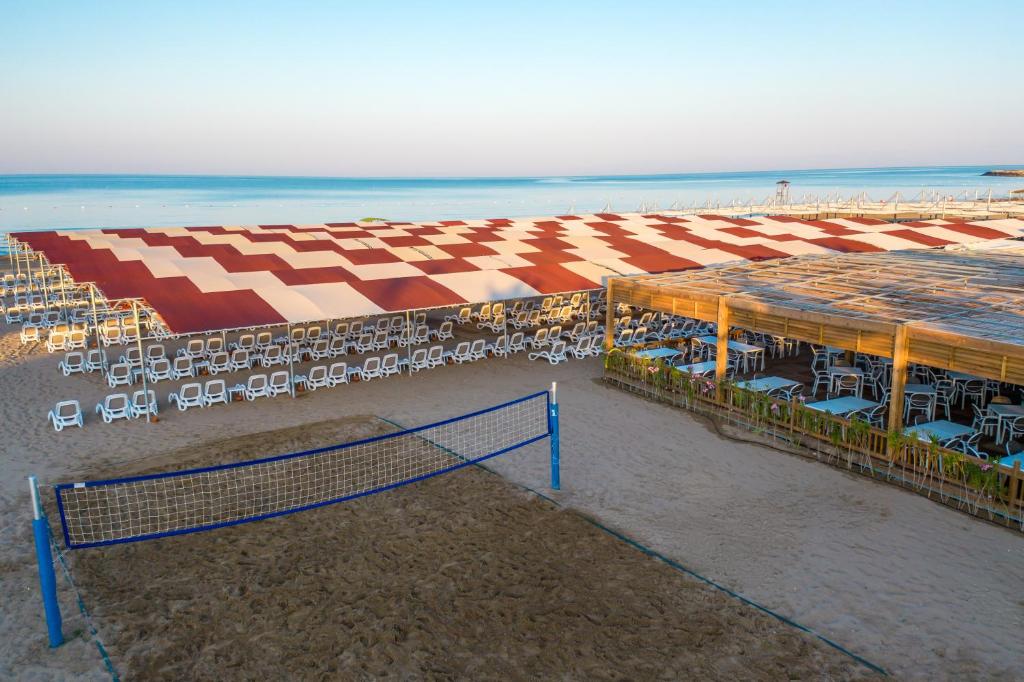 Piekrastes zona ar pludmales krēsliem un volejbola laukumu pie Side Royal Style.