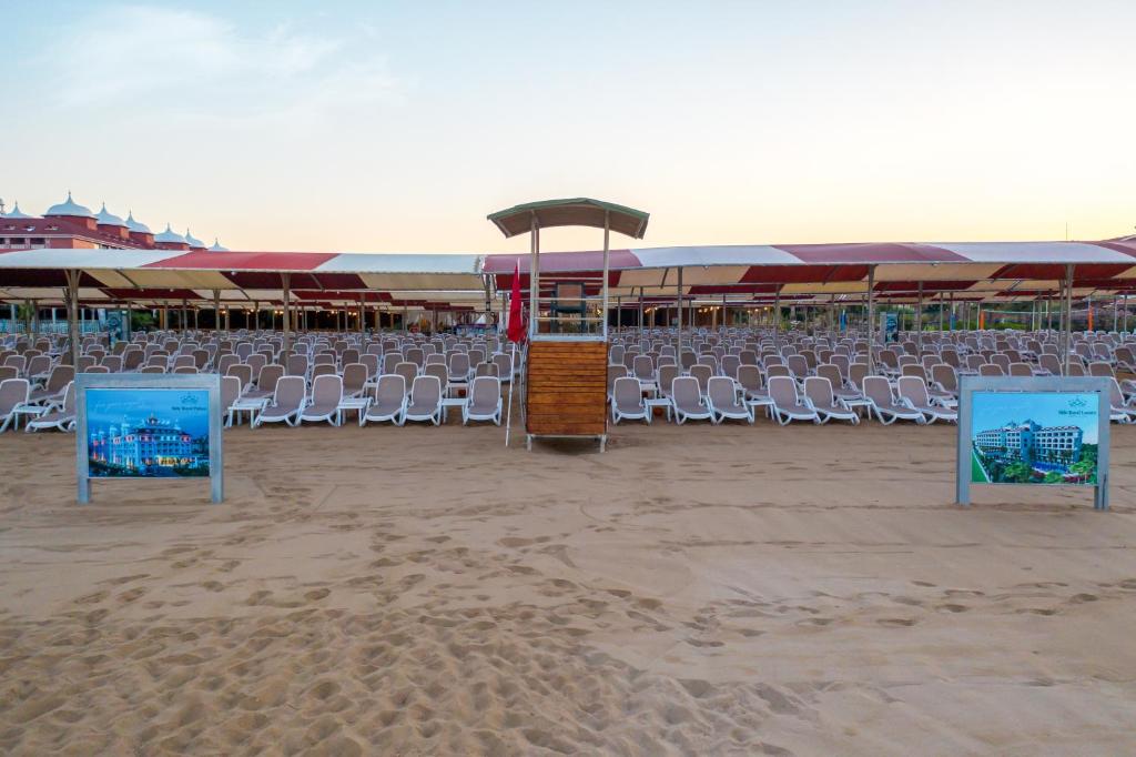 Pludmale ar sauļošanās krēsliem pie Side Royal Style viesnīcas