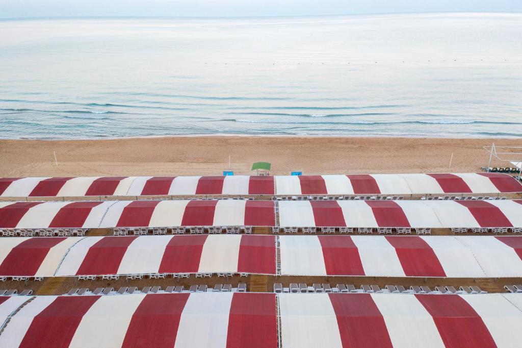 Peldvietas ar sauļošanās krēsliem pie Side Royal Style, piekrastē.