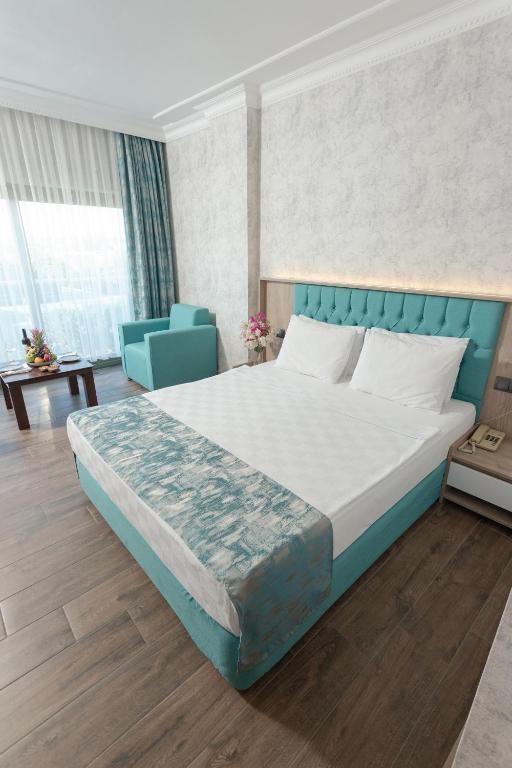 Mūsdienīgs numurs Anadolu Hotels Didim Club ar balkonu un skatu uz dārzu.