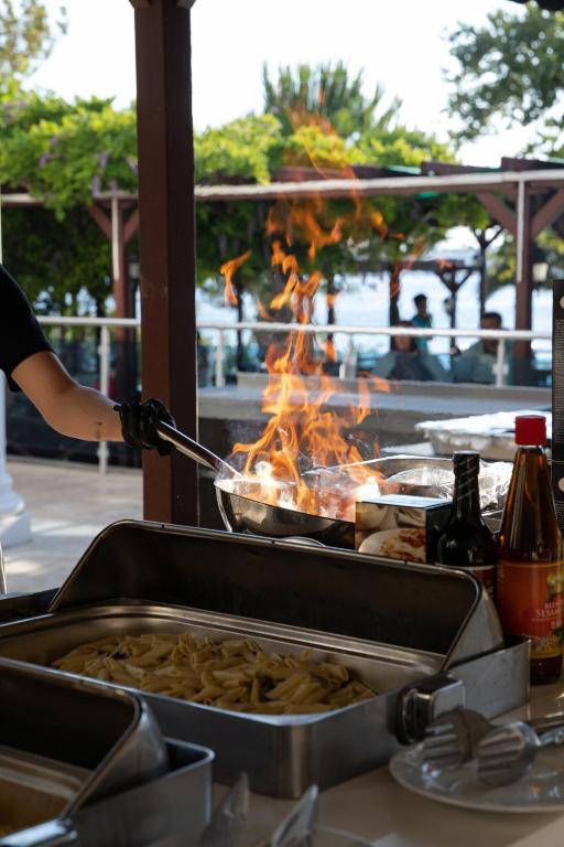Viesnīcas Anadolu Hotels Didim Club šefpavārs gatavo maltīti ar liesmām.