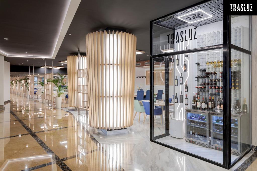 Moderns interjers ar elegantu vīna displeju un apgaismojumu, radot stilīgu atmosfēru. Telpā ir redzami augstas kvalitātes apdares elementi un augu akcenti.