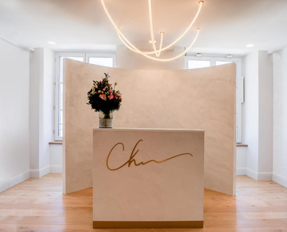 Viesnīcas Fleur de Loire reģistratūra ar modernu apgaismojumu un ziedu kompozīciju.