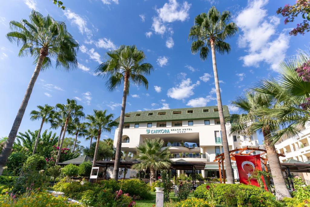 L'ancora Beach Hotel piekrastes ainava ar palmu kokiem un zilu debesīm
