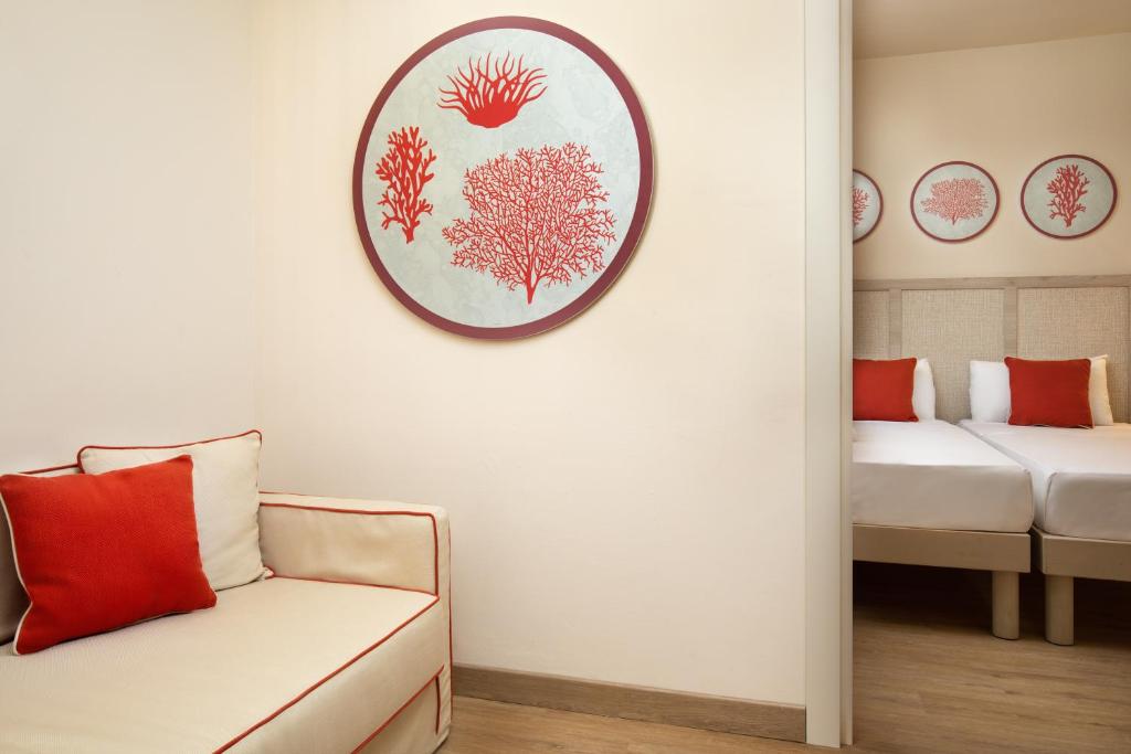 Mūsdienīgs viesnīcas numurs ar sarkaniem akcentiem un stilīgu korālu dekoru uz sienām, kas rada patīkamu un relaksējošu atmosfēru.
