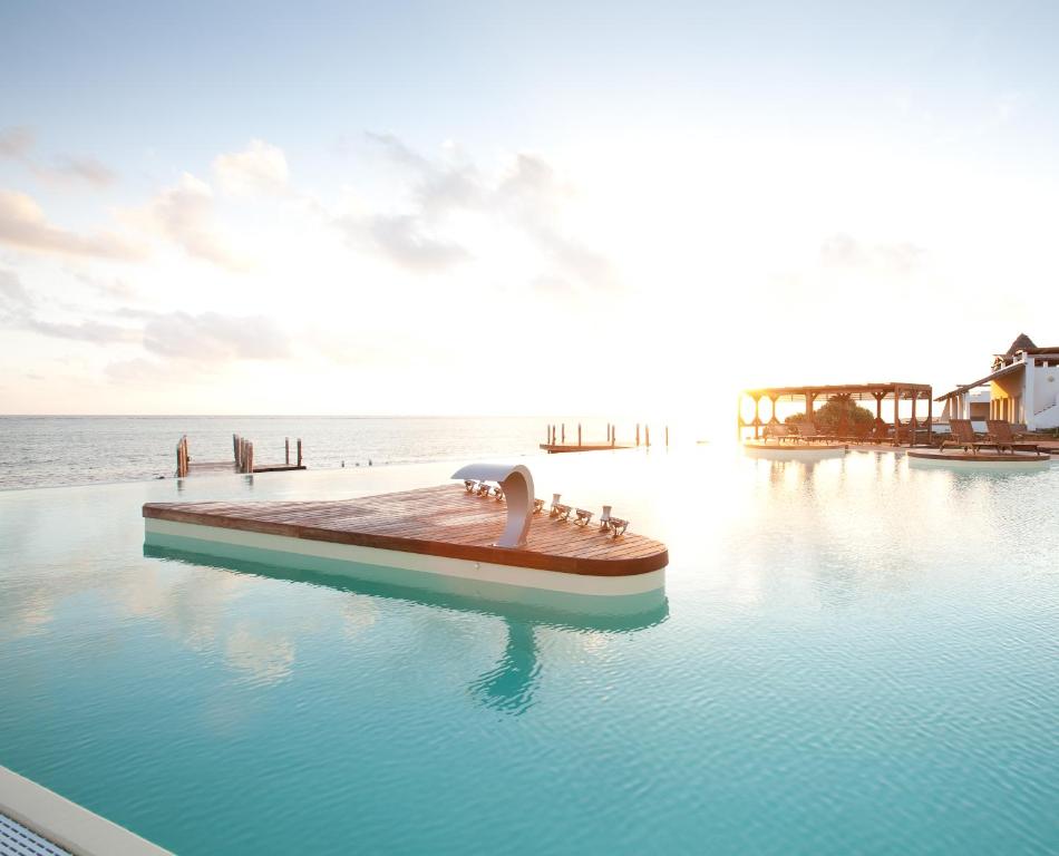 Essque Zalu Zanzibar baseins ar skatu uz saulrietu piekrastē.