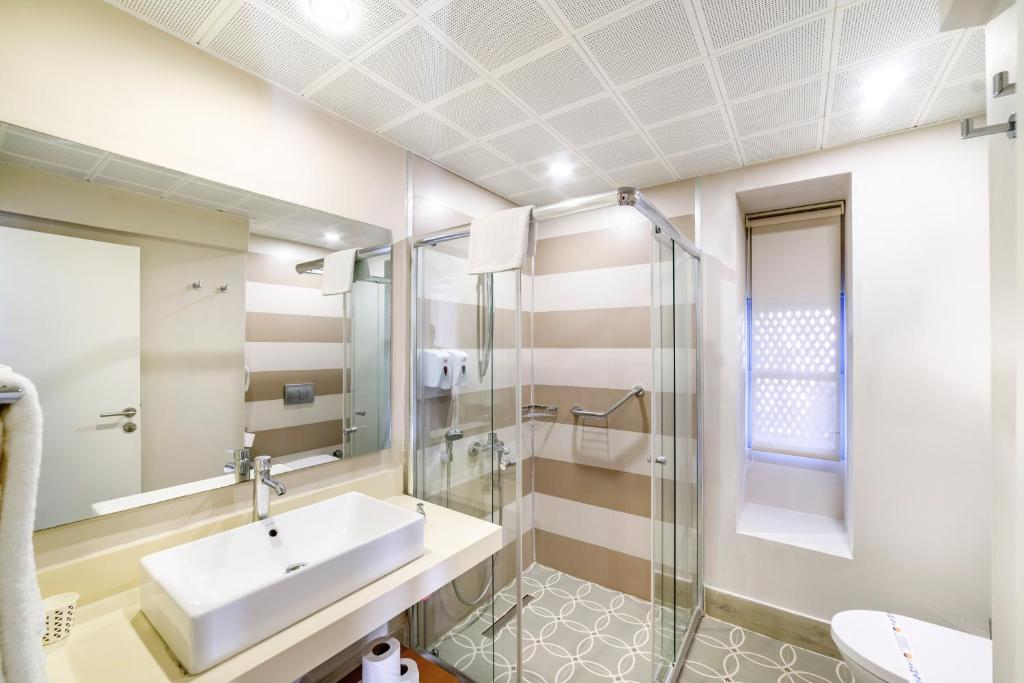 Mūsdienīgs vannas istabas dizains Ulusoy Kemer Holiday Club ar stikla dušu.