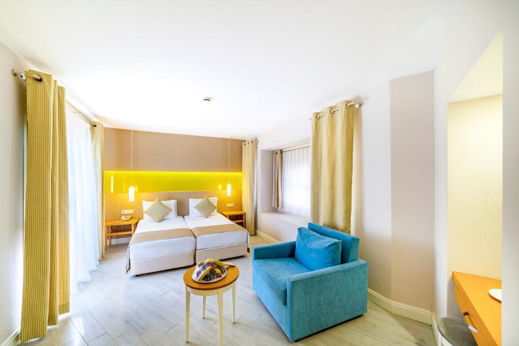 Mūsdienīgs numurs Ulusoy Kemer Holiday Club ar divām gultām un dīvānu.