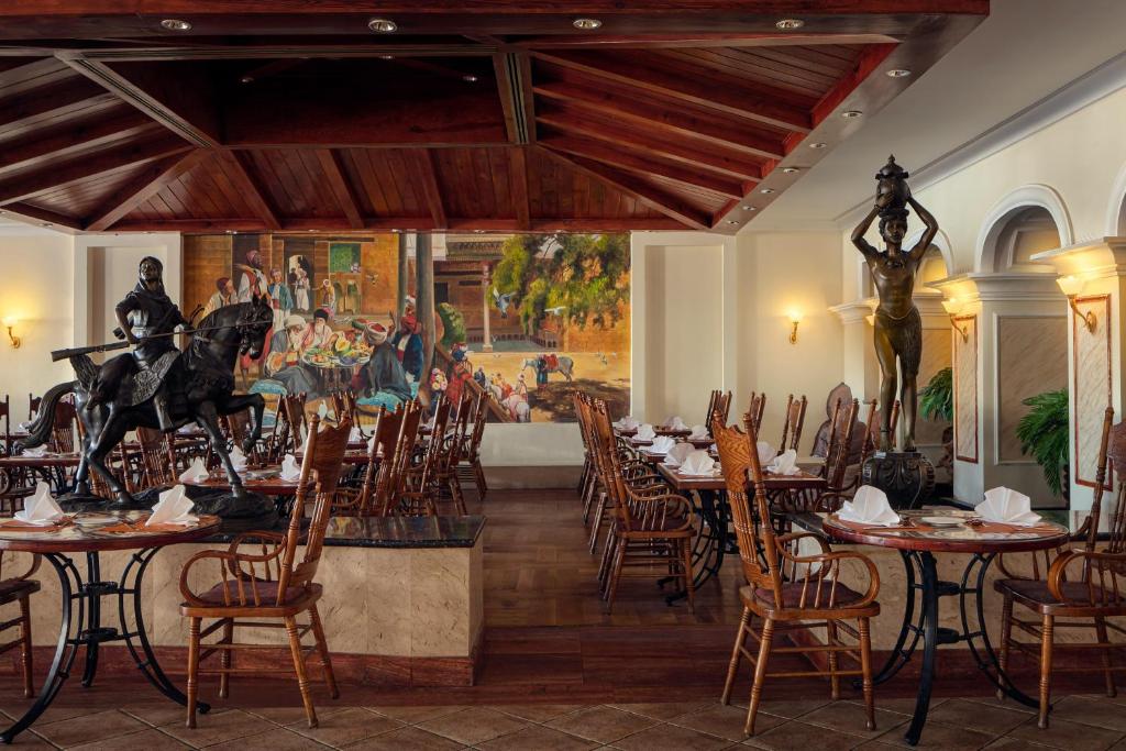 Restorāns Palm Royale Resort - Soma Bay ar mākslas darbiem un statujām.