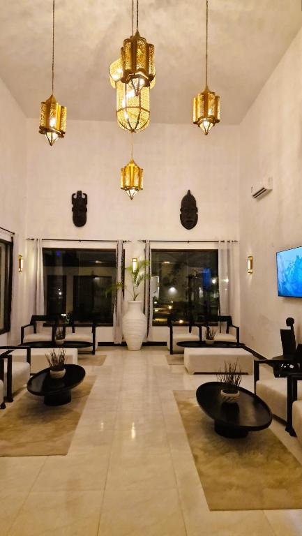 Mūsdienīga viesistaba ar augstiem griestiem, dekoratīvām lampām un melnu un baltu mēbeļu kombināciju, kas rada elegantu un stilīgu atmosfēru. Telpā ir lieli logi, caur kuriem plūst dabiska gaisma.