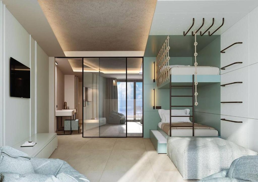 Moderna viesnīcas numura dizains ar stikla sienām, augšējo gultu un mūsdienīgu iekārtojumu. Telpa ir gaiša un plaša, radot patīkamu atmosfēru.