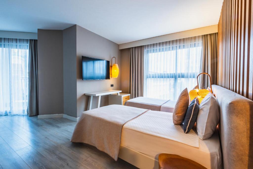 Numurs ar divām gultām un televizoru, Side Royal Style viesnīcā.