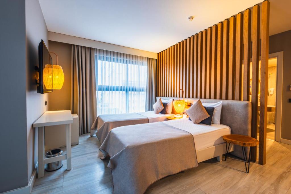 Numuri ar divām gultām un modernu interjeru viesnīcā Side Royal Style.