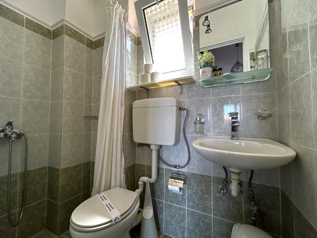 Maza, moderna vannas istaba ar pelēkām flīzēm, tualeti un izlietni. Iekārtota ar logu, kas nodrošina dabisko apgaismojumu.