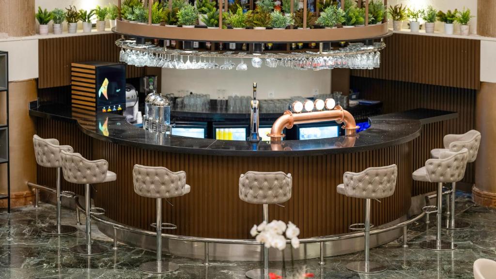 Bārs viesnīcā Numa Club Side ar elegantiem krēsliem un dzērieniem