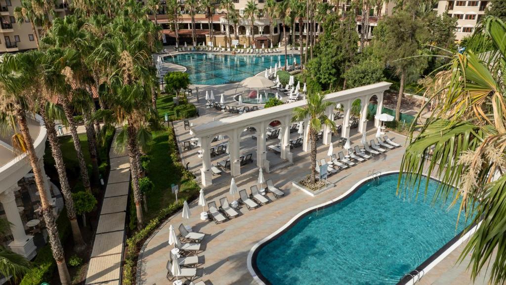 Lielais baseins un saules terase pie Numa Club Side, apkārt palmām.