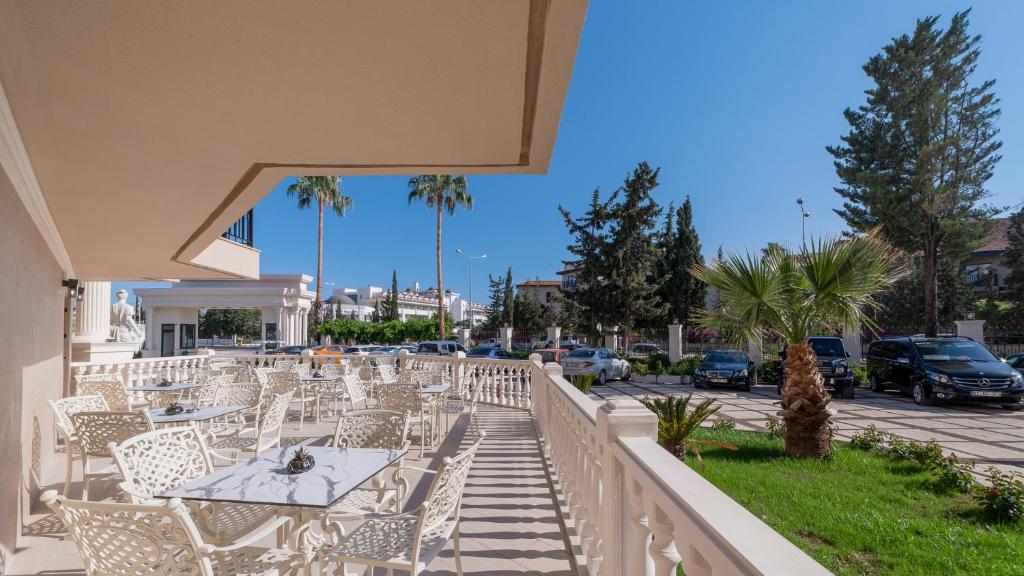 Terase ar baltām mēbelēm pie viesnīcas Numa Club Side, zila debess.