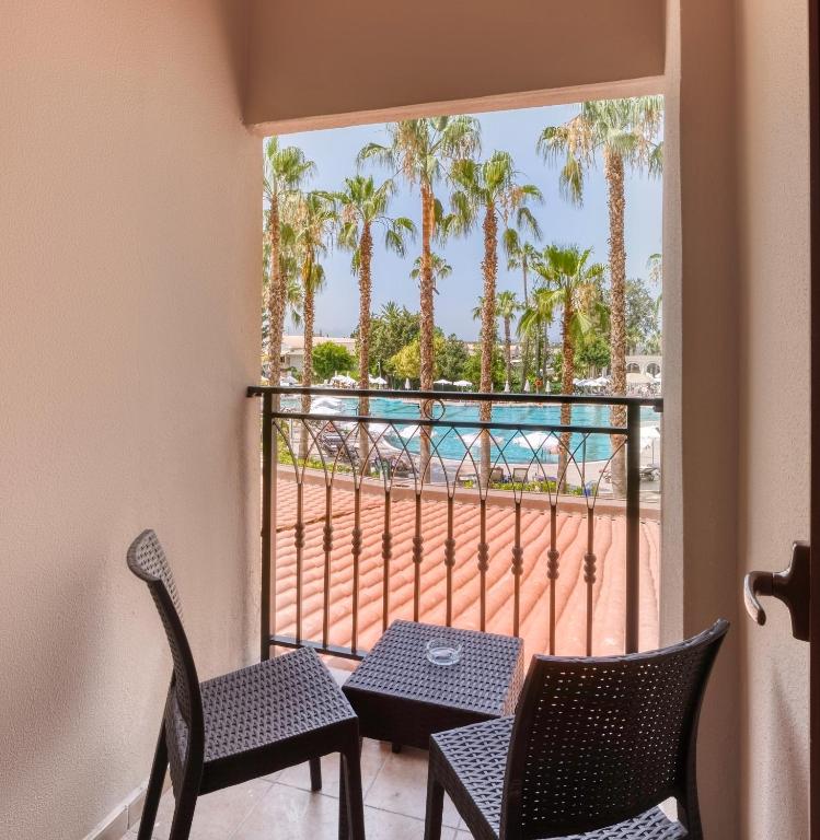 Skats no balkona uz baseinu un palmu kokiem Numa Club Side