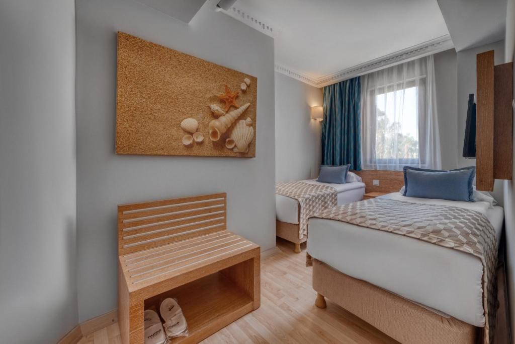 Mūsdienīgs numurs viesnīcā Numa Club Side ar divām gultām un jūras tematiku.