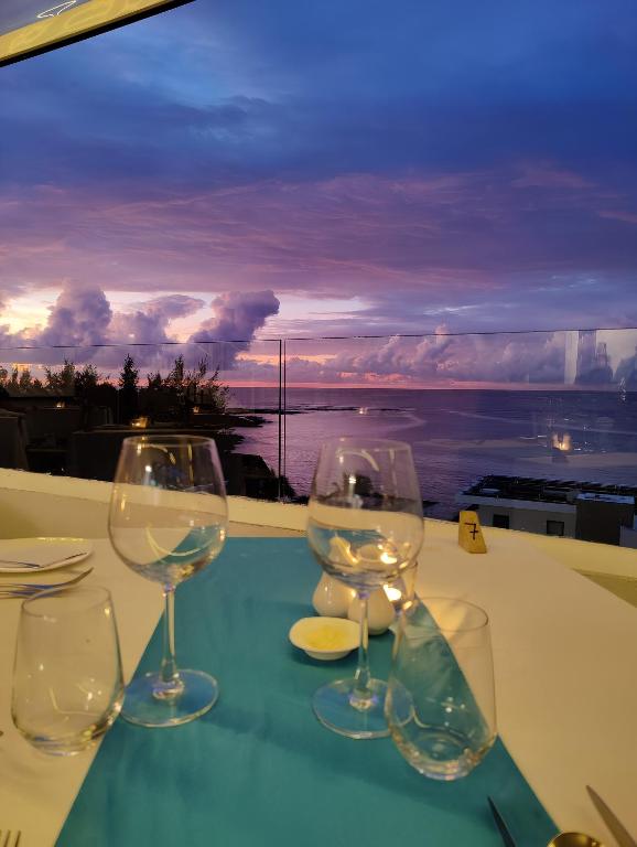 Skats uz saulrietu no restorāna Ocean V, elegantas galda iestatījums.