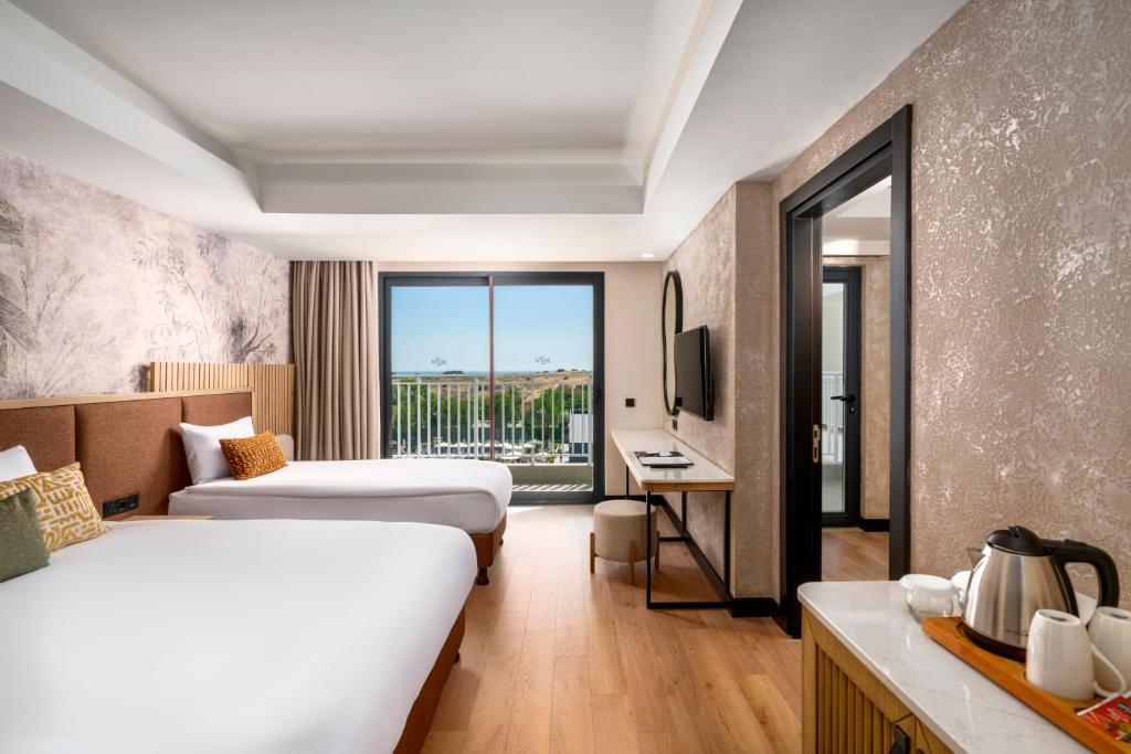 Vox Maris Resort numurs ar divām gultām un balkonu pie jūras.