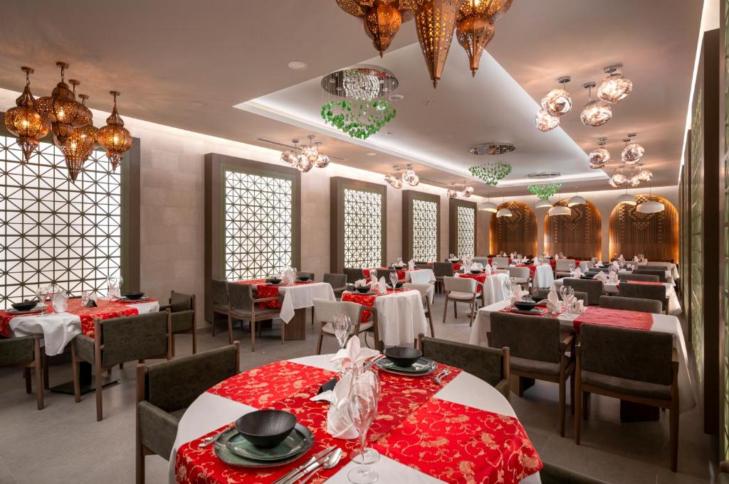 Vox Maris Resort elegantā restorāna interjers ar sarkaniem galda veļām un unikālu apgaismojumu.